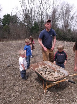 Dan, Zion, Harvey, and friends, with a wheelbarrow of rocks and some weedy ground