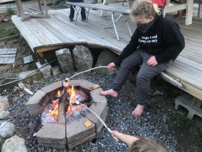 Harvey and Zion toasting marshmallows over the fire