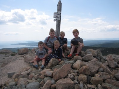 the boys posing with friends on a mountaintop