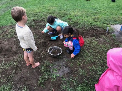 Lijah playing in the mud with other kids at Park Day