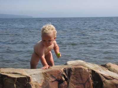naked Lijah climbing on the rocks