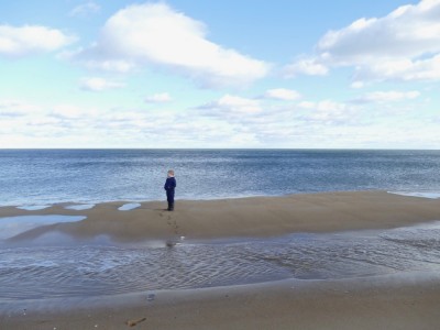Zion standing on a sandbar on the beach at Plum Island