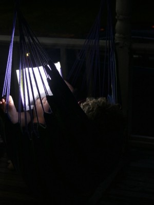 Harvey reading in the hammock chair with a headlamp
