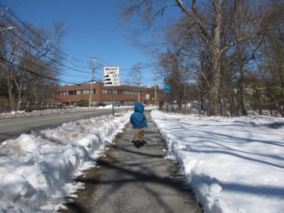 Lijah walking down the sidewalk, snow on either side