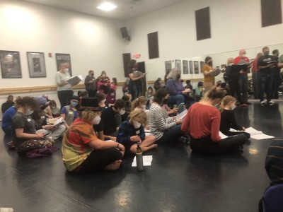 Harvey and Zion sitting on a dance studio floor for opera rehearsal