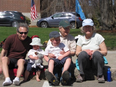 Harvey, Zion, Grandma, Grandpa, and another Grandpa sitting on the curb waiting for the parade