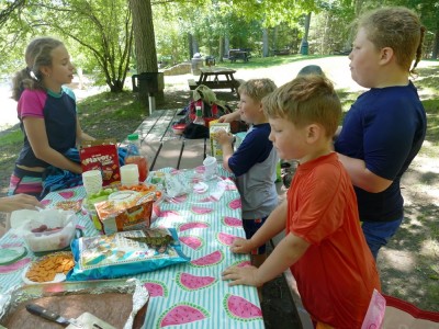 the kids at a picnic table loaded with treats