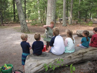 the boys sitting with other kids listening to a park ranger