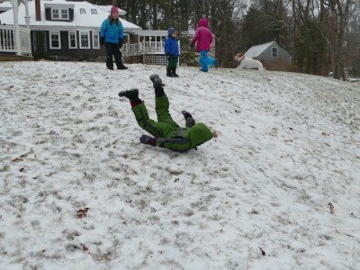 Zion sliding down a slightly-snowy hill on his belly