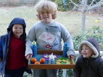 the boys proudly displaying their carefully arranged picnic tray on the porch