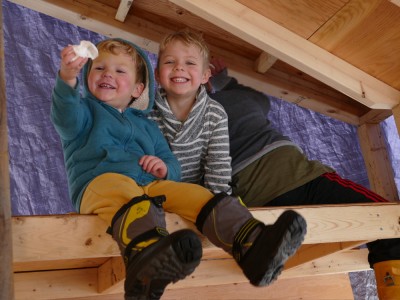 the boys smiling in the half-built playhouse