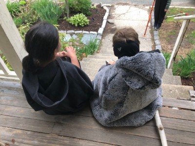 Elijah and a friend sitting on the porch steps wearing robes