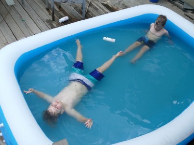 Zion and Elijah floating in the inflatable pool