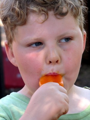 Harvey eating an orange popsicle