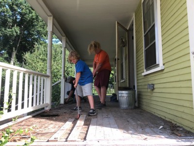 Harvey and Zion prying up porch boards