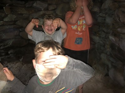 the boys shielding their eyes from the camera flash in a root cellar cave