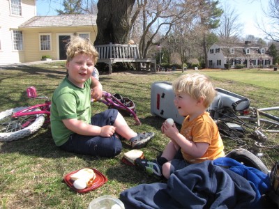 the boys eating a picnic lunch by the bikes
