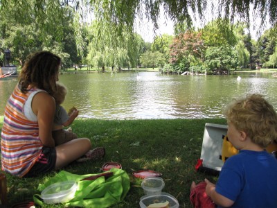 Leah, Harvey, and Zion picnicing by the pond in the Public Garden