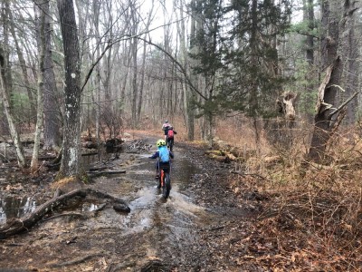 the boys riding through a giant puddle on the trail