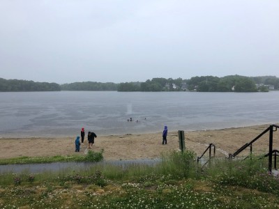 Freeman Lake in the rain, with some kids swimming and others playing on the beach