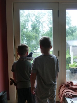 Zion and Elijah looking out the back door at the rain