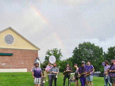 the Party Band with a rainbow behind them