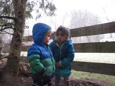 Lijah and a friend playing under the tree on a cold wet day