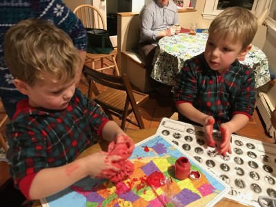 Lijah and Zion with messy red hands mixing paint into playdough