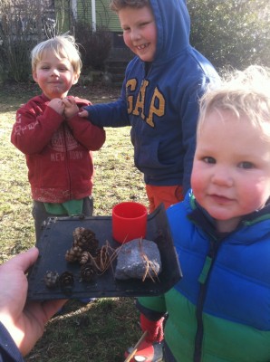 the three boys offering a tray of delicacies from their outdoor restaurant
