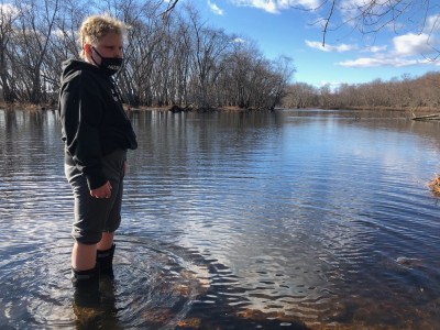 Harvey standing in the Concord River in his boots