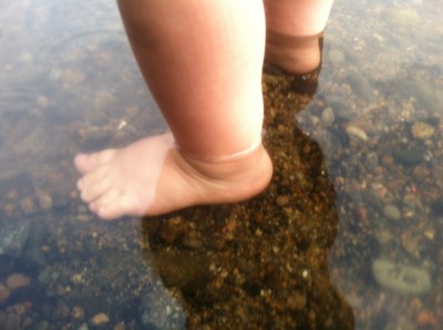 Lijah's bare feet in the shallow water