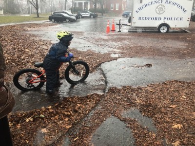 Elijah getting ready to ride his bike through a stream of run-off by the playground