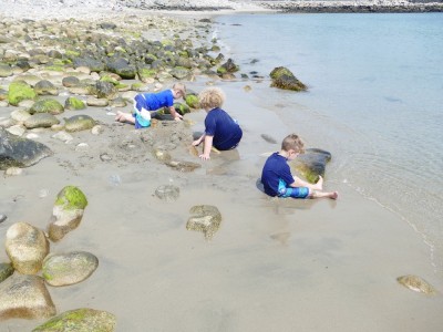 the boys making sand walls among beach rocks
