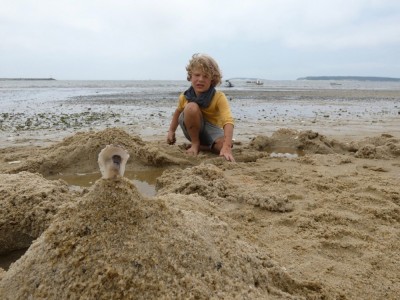 Elijah behind a sand castle