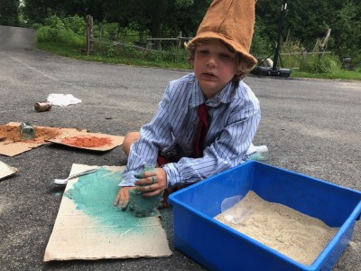 Elijah making colored sand wearing a top hat