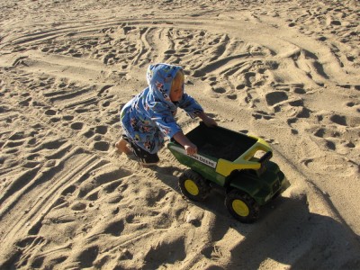 Zion pushing the big toy truck accross the sand
