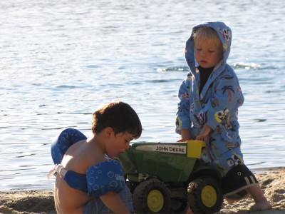 Zion and Julen playing in the sand by the water