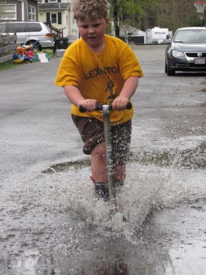 Harvey riding his scooter into a giant puddle