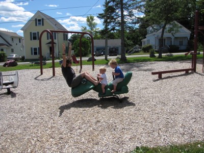 Mama, Harvey, and Zion on a playground alligator