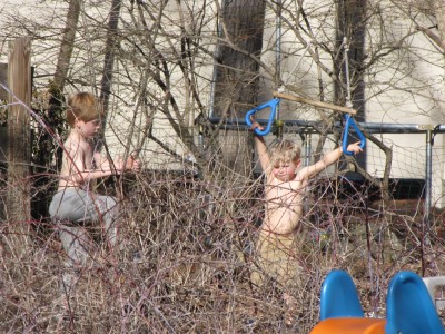 Zion and Nathan playing shirtless in the yard