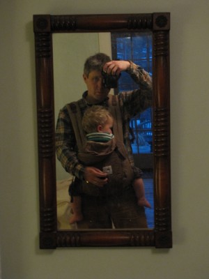 a picture of me in the mirror, with Lijah sleeping in the front-pack