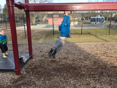 Zion zipping across a playground zip line