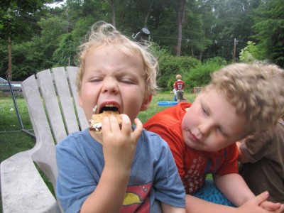 Harvey watching while Zion opens wide to take a bits of smore