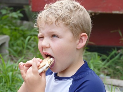 Zion making a face as he bites into a smore