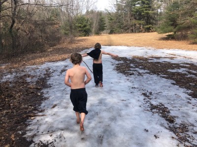 Zion and Elijah walking on snow shirtless, Elijah barefoot