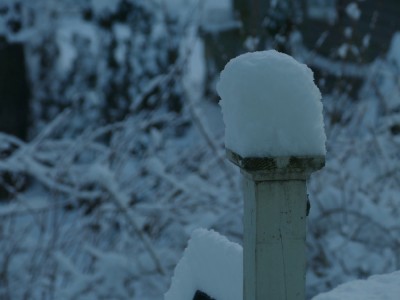 a tall cap of snow on a porch post