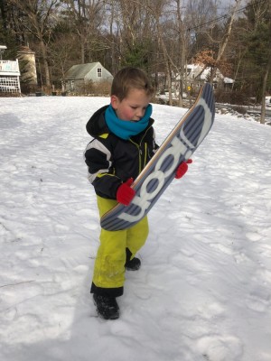 Elijah holding a friend's snow skate