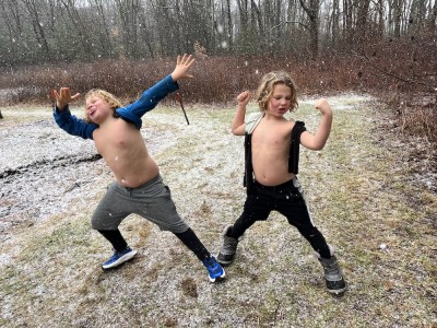 Zion and Elijah posing shirtless in the falling snow