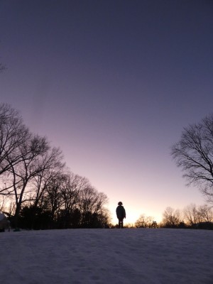 Harvey standing on the top of the sledding hill at sunset