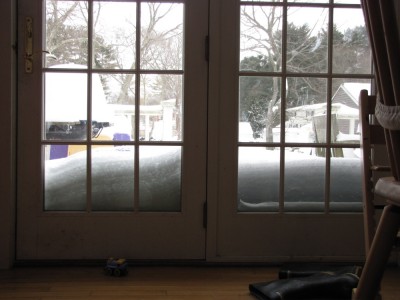 the view out onto the back porch, with snow piled against the doors